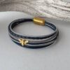 das Lederarmband mit einer goldener Biene blau-grau