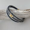 das Lederarmband mit einer goldener Biene in blau-grau