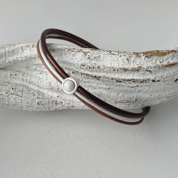 das Lederarmband in braun mit einem weißem Stein